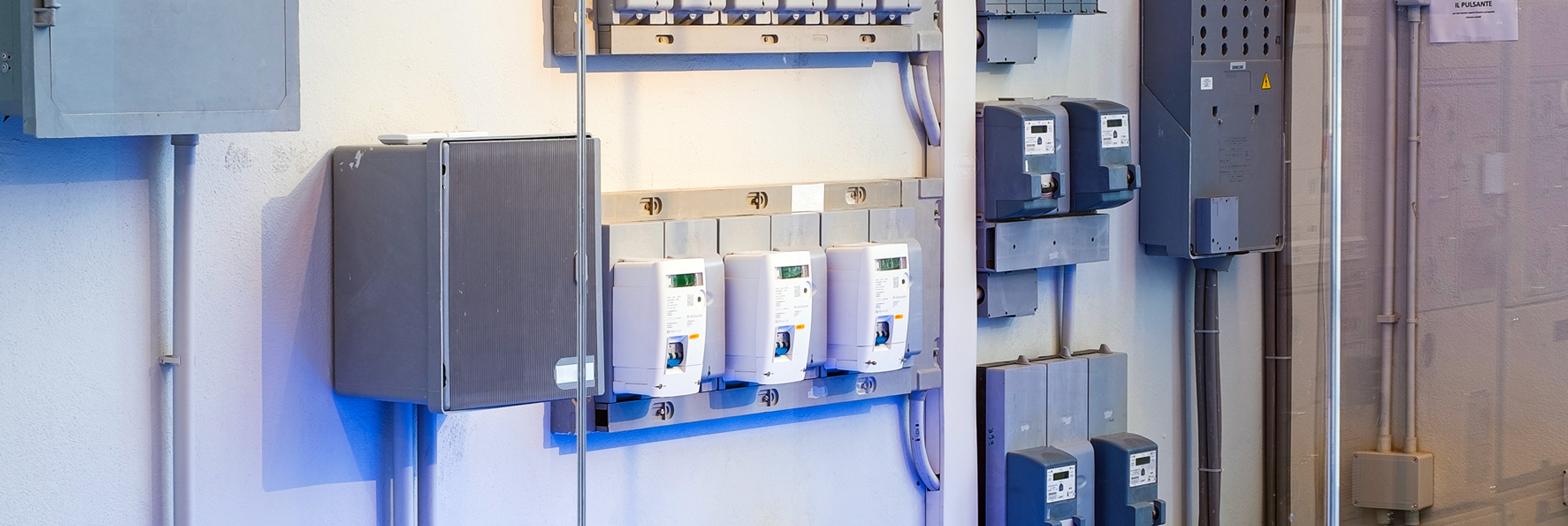 Tre contatori elettrici montati a parete