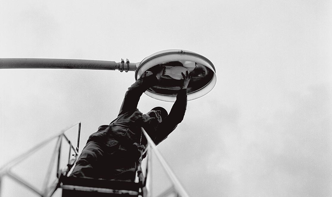 Immagine d'epoca di un tecnico ACEA al lavoro su un lampione