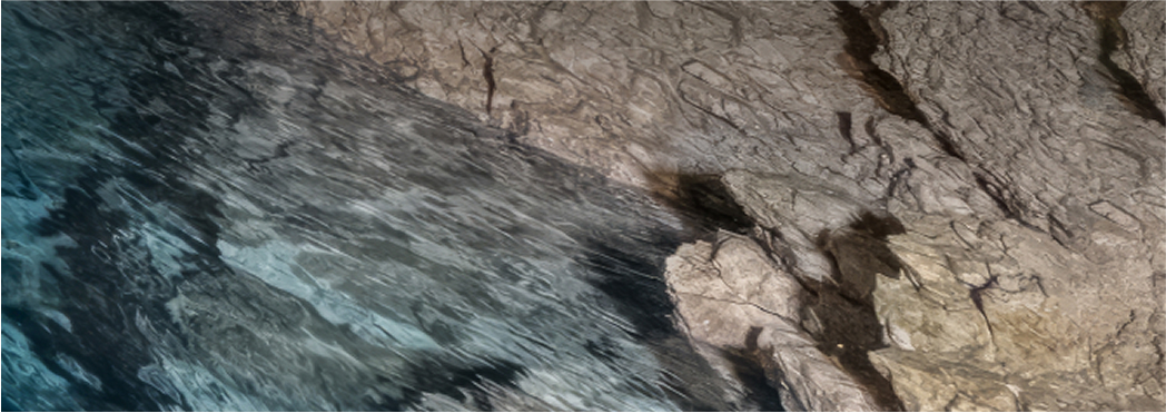 Cave with crystal clear blue water and rocky walls