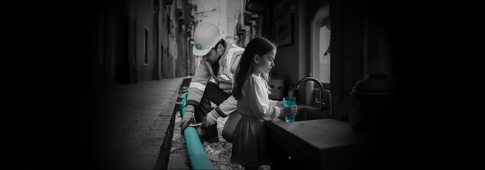 Operaio Acea lavora alla manutenzione di una condotta, mentre una bambina riempie il bicchiere con acqua del rubinetto