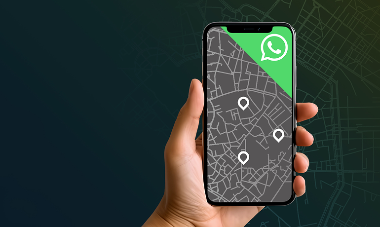 mano che tiene un telefono in cui si vede una mappa con dei pin e il logo whatsapp