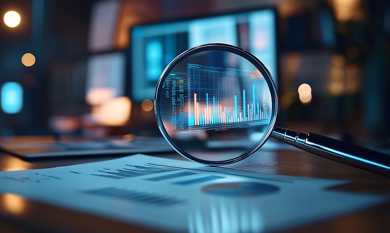 Una lente d'ingrandimento con un grafico a barre sullo schermo di un computer.
