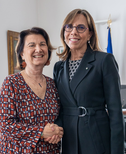 Eugenia Roccella e Barbara Marinali sorridono verso la fotocamera mentre si stringono le mani