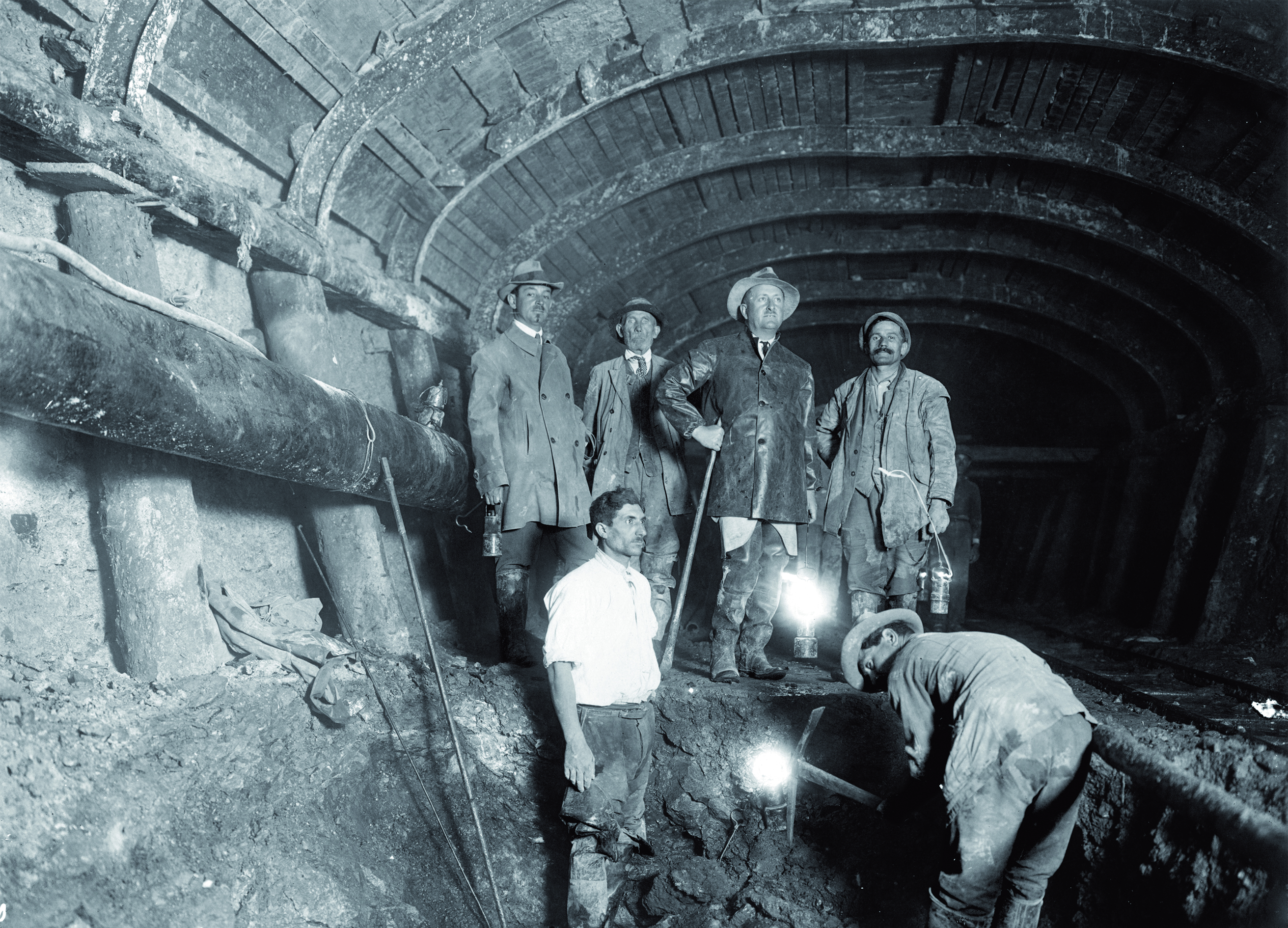 foto in bianco e nero di operai che lavorano in una galleria
