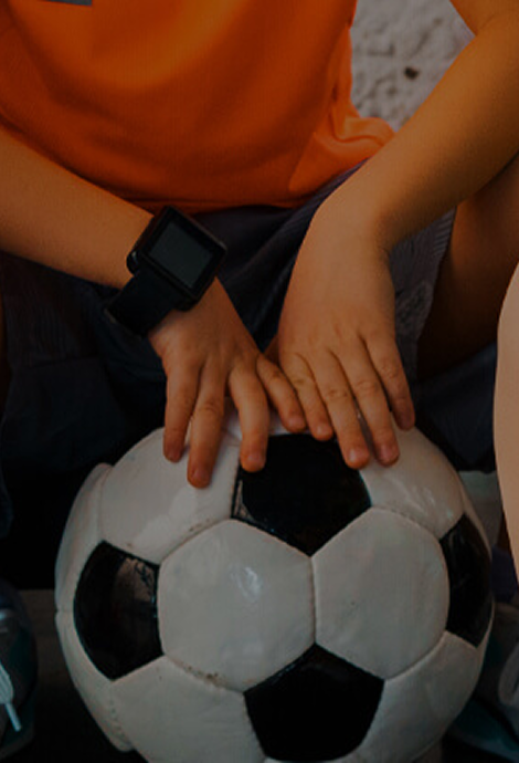 mani di un bambino che tengono fermo un pallone