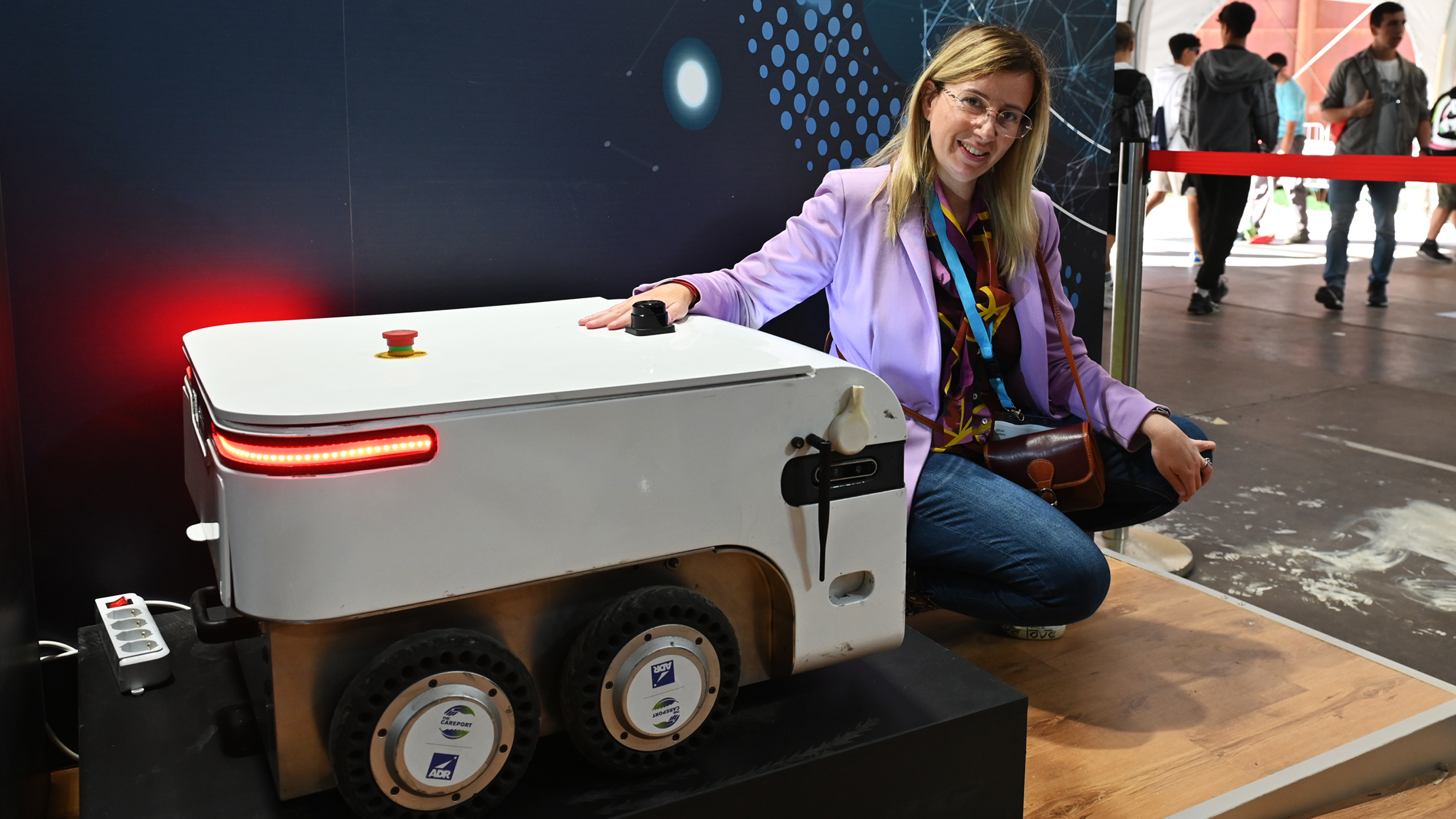 Una partecipante all'evento fotografata accanto ad uno dei prodotti in esposizione da Acea