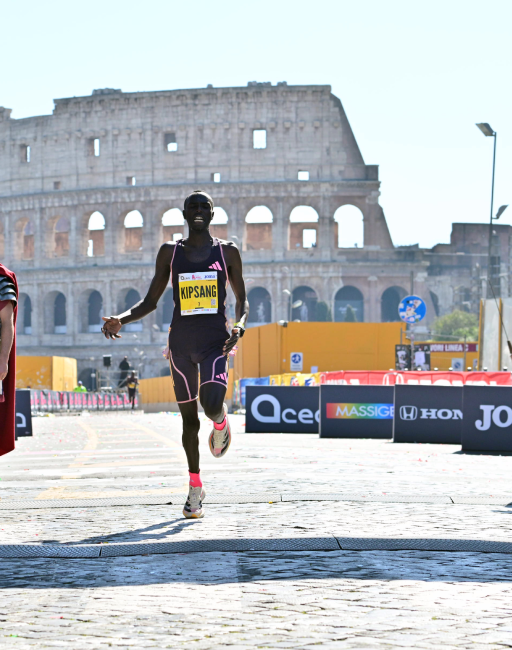 Atleta keniano Kipsang corre verso il traguardo con il Colosseo sullo sfondo durante la ACEA Run Rome the Marathon 2024
