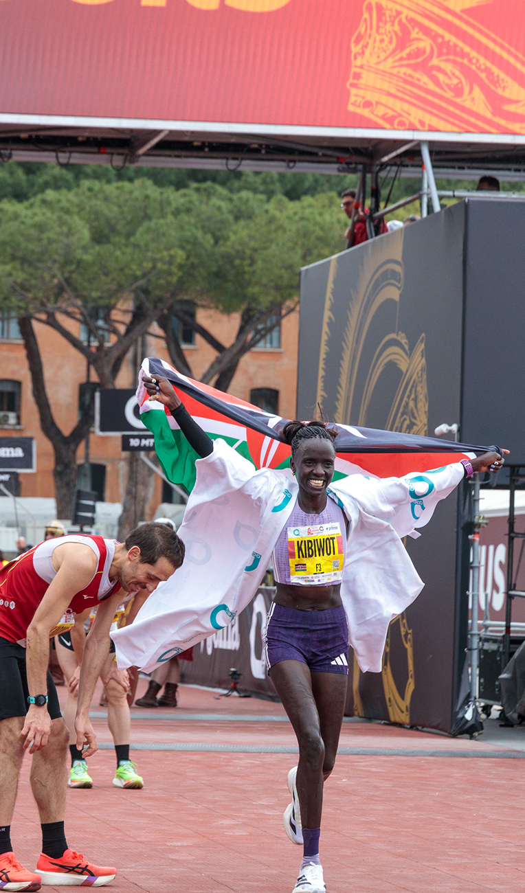 Pascaline Kibiwot crosses the finish line at the acea run rome the marathon carrying the Kenyan flag