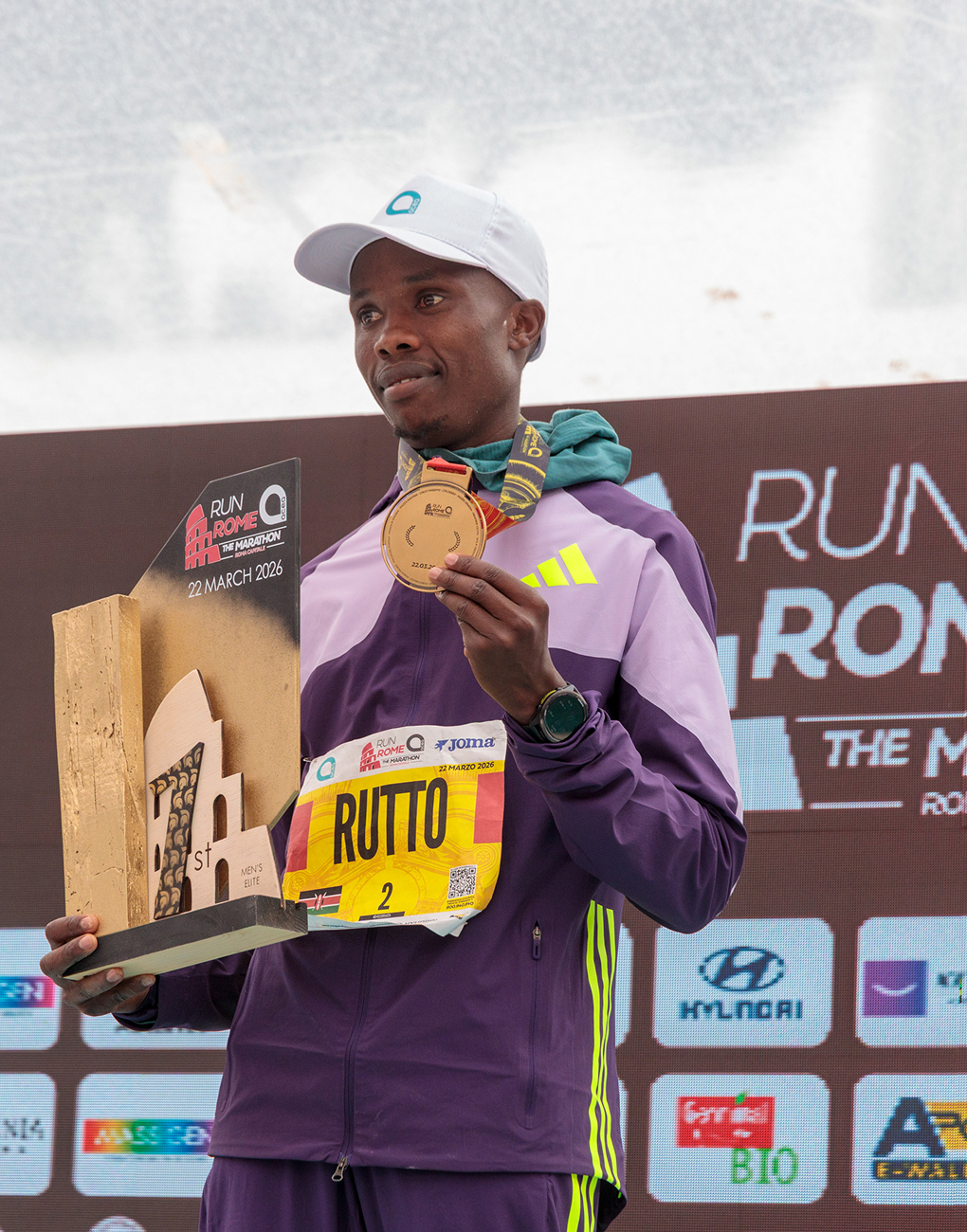 Asbel Rutto, winner of the acea run rome the marathon, shows off his gold medal on the podium