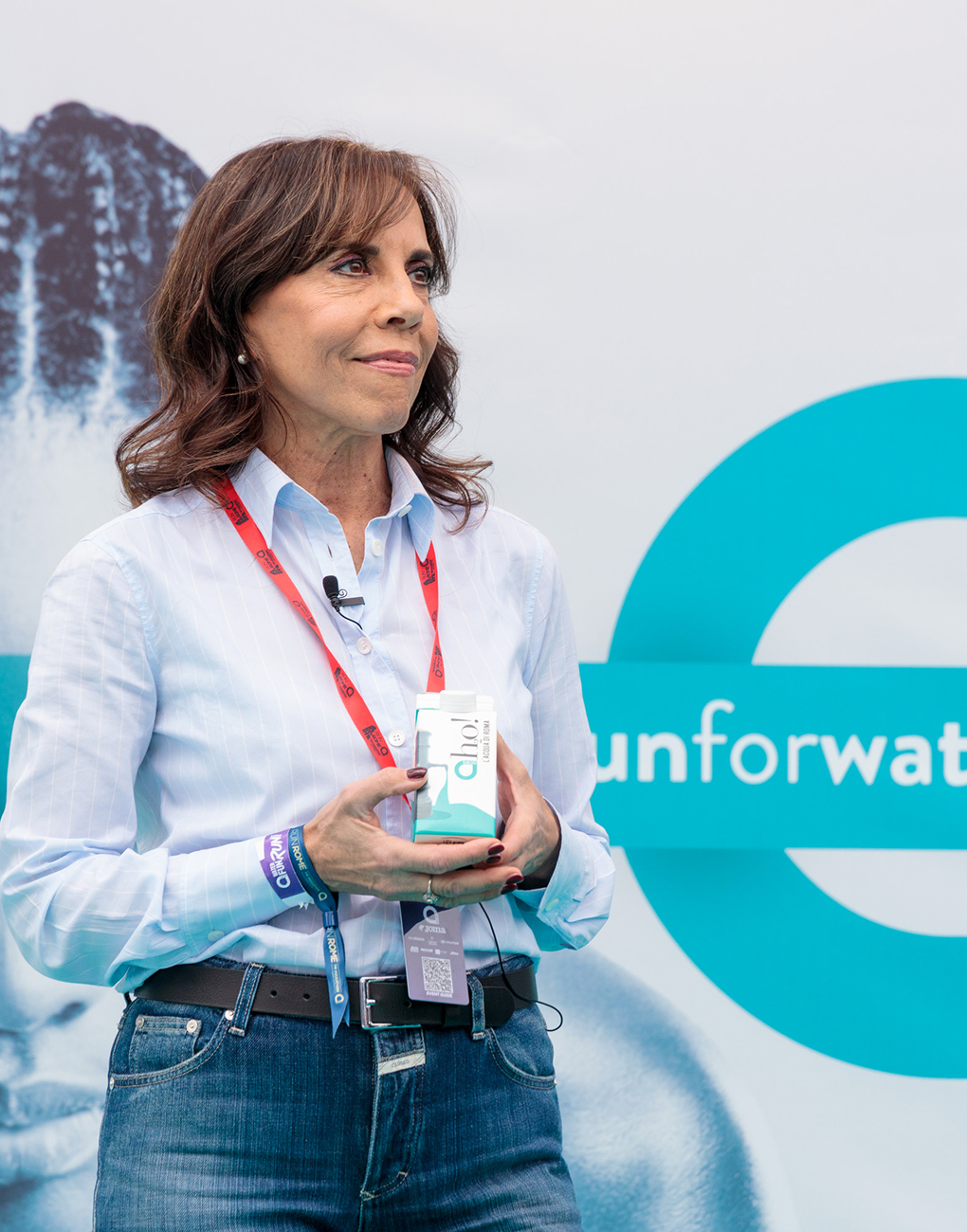 Barbara Marinali, president of Acea, poses with a smile, holding a carton of Aho! water.