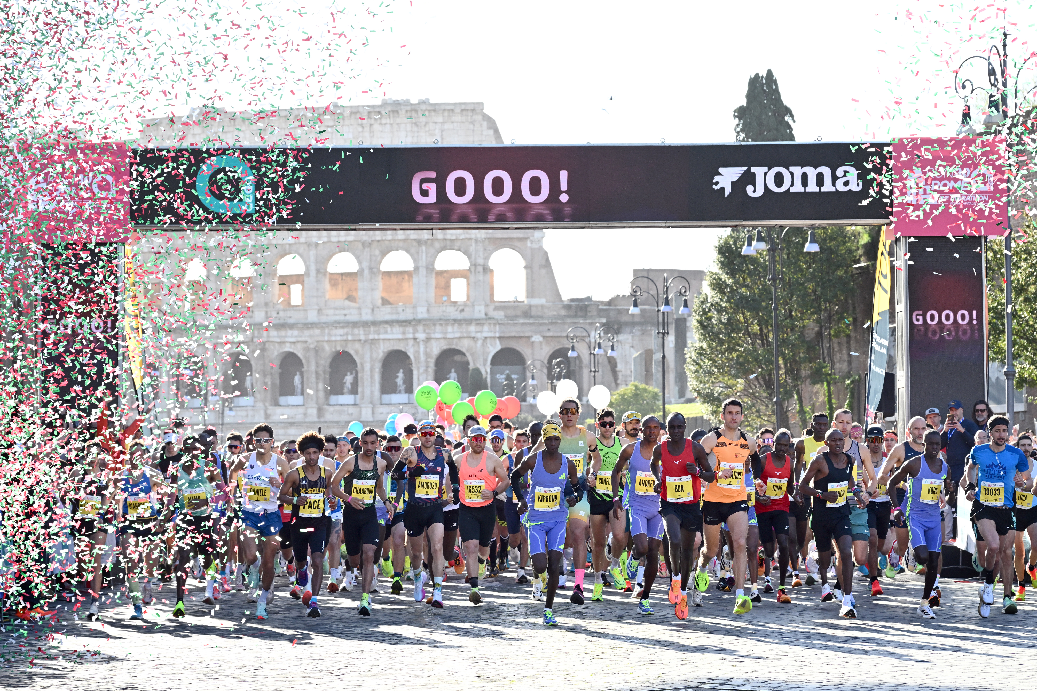 I vincitori mentre tagliano il traguardo, gli altri corridori a seguire. Ci sono anche i coriandoli esplosi