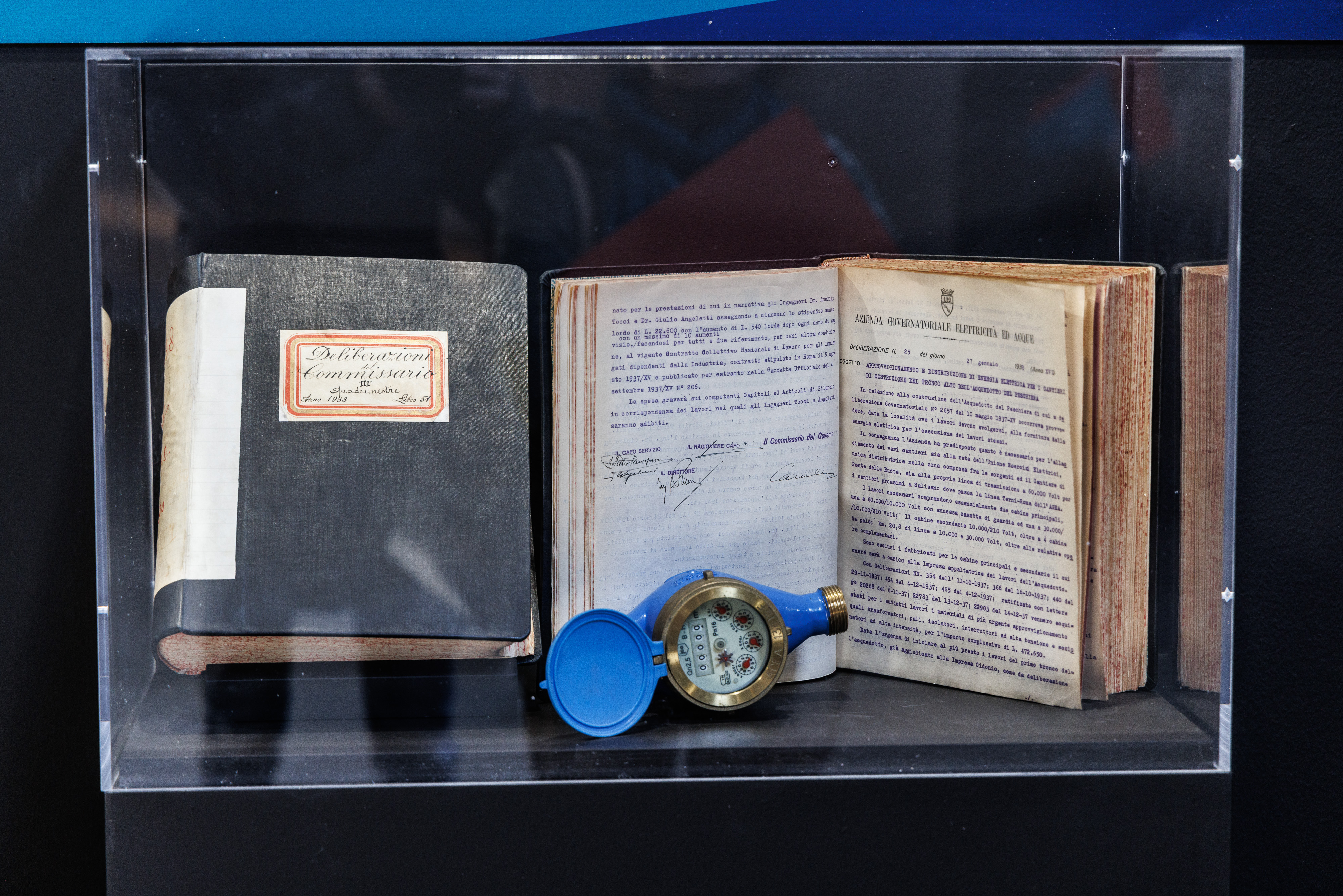 una teca con dentro un reperto archeologico e due libri antichi