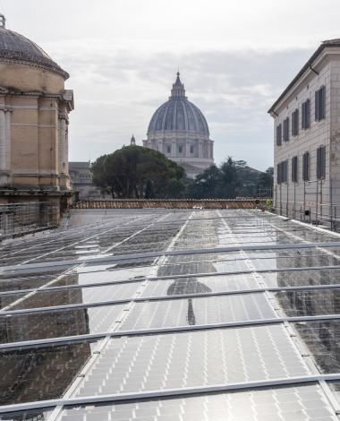 in primo piano si vedono dei pannelli fotovoltaici e sullo sfondo il Vaticano