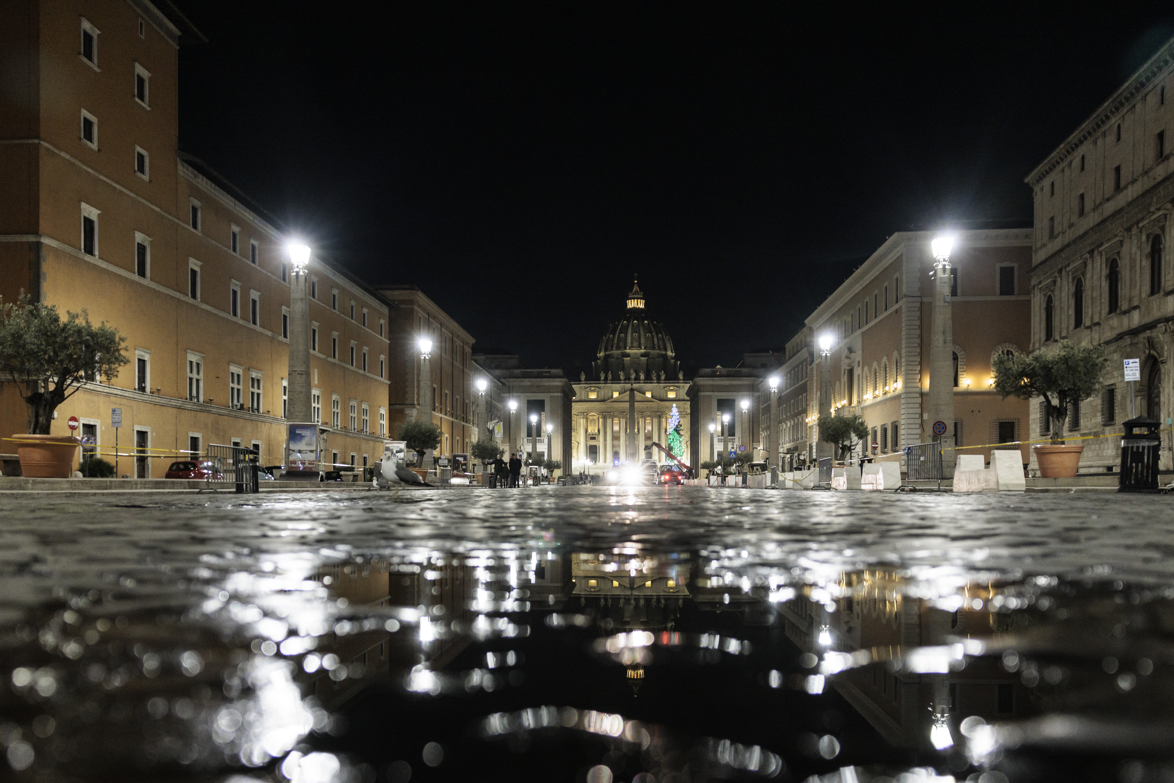 primo piano di via della conciliazione illuminata con la basilica di san pietro sullo sfondo