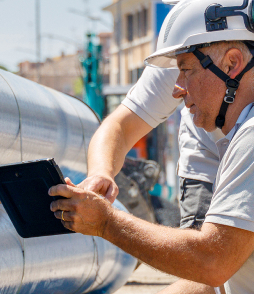 Operatori Acea, in tenuta antinfortunistica, guardano lo schermo di un tablet