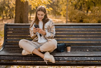 Ragazza che usa lo smartphone su una panchina