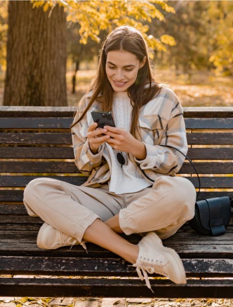 Ragazza che usa lo smartphone su una panchina