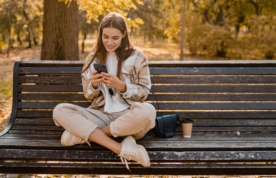 Ragazza che usa lo smartphone su una panchina