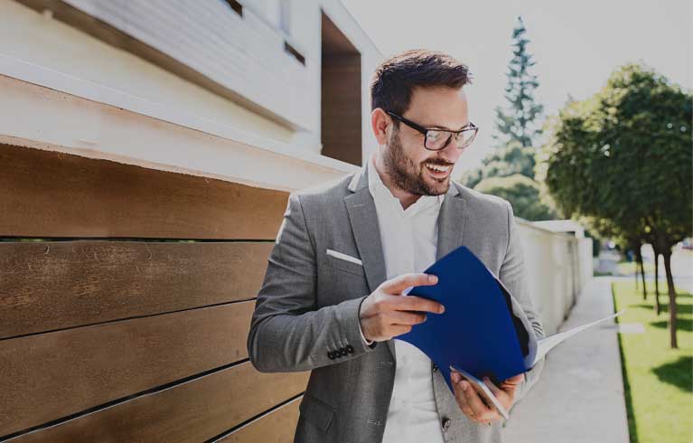 Uomo che legge dei fogli fuori casa