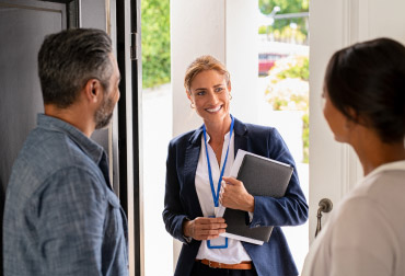 Consulente porta a porta che parla con due persone