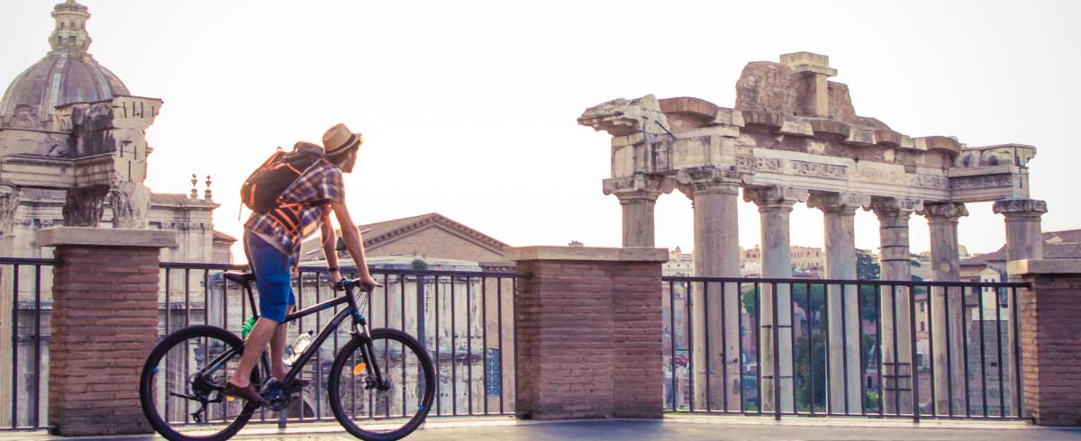 Turista che ammira resti romani da una bicicletta