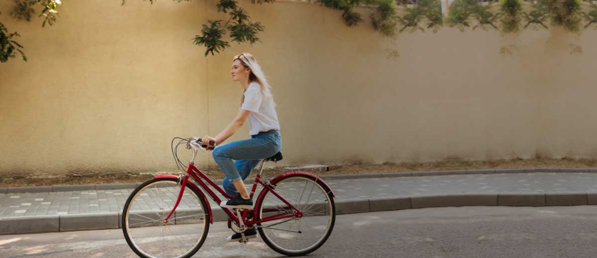 Ragazza pedala in bicicletta in una strada cittadina