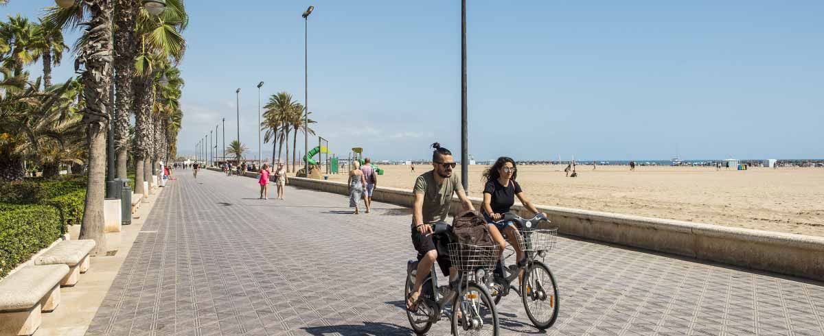 Coppia che si sposta in bici sul lungomare di Valencia