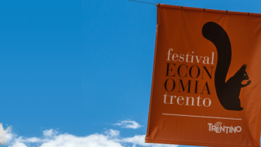 Manifesti del Festival economia di Trento appesi tra gli edifici del capluogo trentino