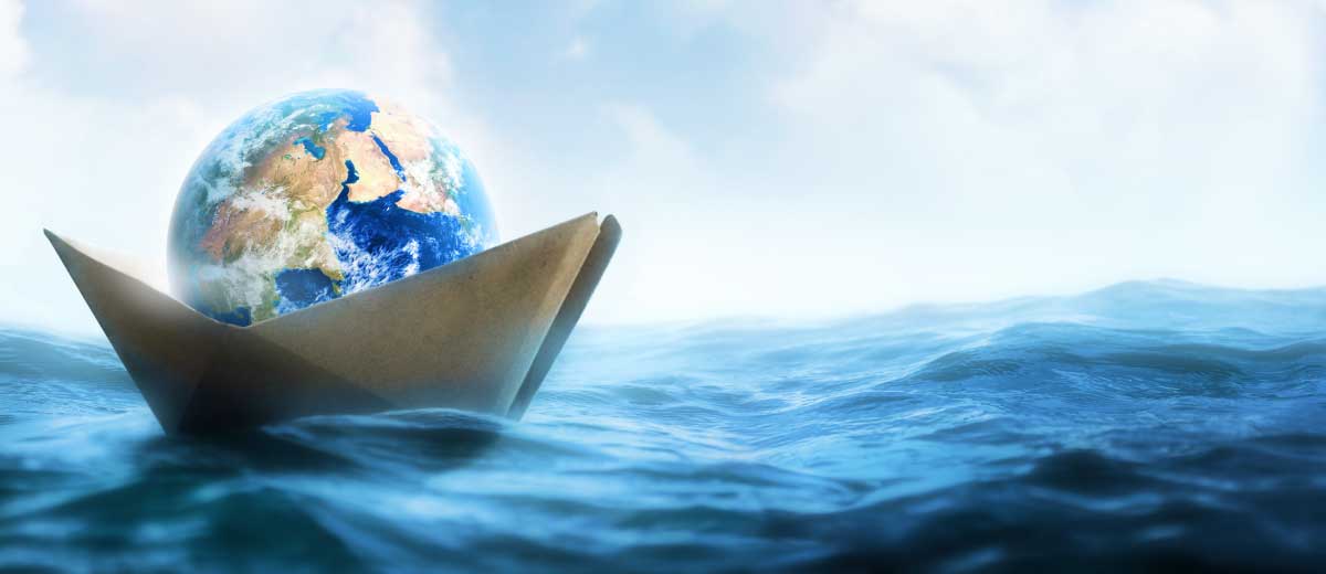 Globo su una barchetta di carta in mezzo all'oceano