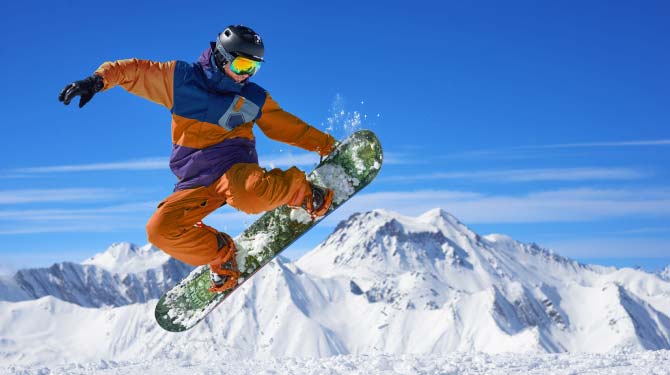 Snowboarder che salta sulla neve