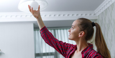 Donna che sostituisce una lampadina