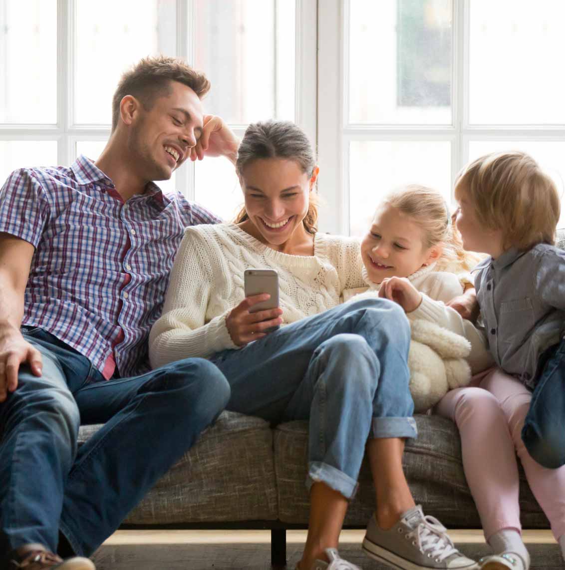 famiglia sul divano che guarda uno smartphone
