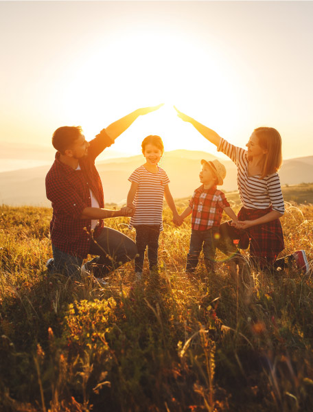 Famiglia che gioca in un prato al tramonto