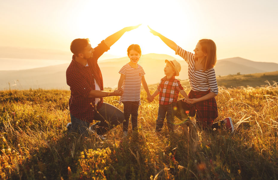 Famiglia che gioca in un prato al tramonto